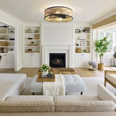 a living room filled with furniture and a fire place in the middle of a room