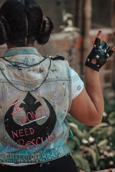 a woman wearing a denim vest with the word i don't need rescue written on it