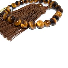 Tiger Eye Japanese Traditional Juzu Buddhist Prayer beads Characteristics of the product Material : Tiger Eye, Silk cord Head bead : about 12mm Main bead : about 8mm Diameter : about 80mm (not stretch) Handmade in Kyoto, JAPAN About juzu One-handed Prayer beads, it can be used by any Buddhist school. In Japan, Buddhists use Prayer beads (Juzu, Nenju). Kyoto is a famous producing center of Prayer beads. Prayer beads are a traditional tool used to count the number of times a mantra is recited, the breaths one takes while meditating, the prostrations, or the repetitions of a buddha's name. About tiger eye Kwown as the gem of courage, the Tiger’s Eye combines properties that promote vitality, help you regain personal power and prevail over emotional blocks. Its bold, encouraging energy is also Brown Tiger Eye, Buddhist Prayer, Personal Power, Silk Cord, Prayer Beads, Tiger Eye, Japanese Traditional, Beads