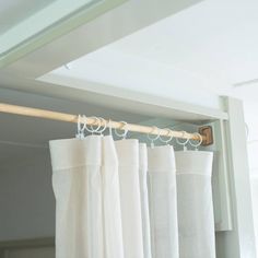 white curtains hanging on a rod in front of a window