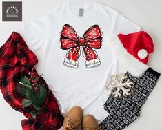 Christmas Coquette Bow Shirt, Christmas Santa Bow Shirt, Santa Claus Bow Shirt, Christmas Lights Shirt, Christmas Mom Gift Shirt, Xmas Holiday Shirt Welcome to MamaBearApparell! I am a professional designer and a Mama of twins. As a professional designer, I am delighted to offer you designed t-shirts that your entire family will love and cherish, making your special moments even more beautiful. We are working to provide you with high-quality soft t-shirts and sweatshirts with trendy designs. We prioritize quality materials and stunning designs to offer you the best service possible. Our handmade items will be the perfect choice for your celebrations, vacations, graduations, or birthday & wedding parties and holidays (such as Christmas, Thanksgiving ..)  Discount available on bulk orders! F Red Christmas Shirt For Holiday, Holiday Gift Red T-shirt, Red Festive Holiday T-shirt, Festive Red Holiday T-shirt, White Festive Shirt For Christmas, White Festive Christmas Shirt, Red Christmas Top For Gift, Red Christmas Tops As Gift, Red Christmas Top As Gift