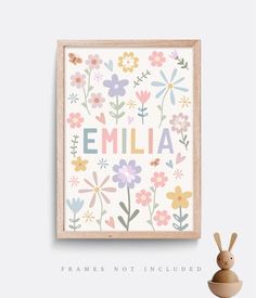 an animal toy next to a framed print with the word'emlia'on it