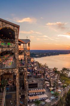 an outdoor restaurant overlooking the water at sunset