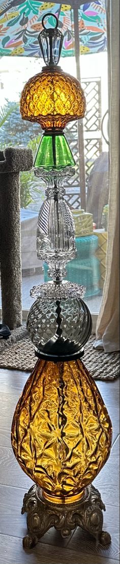 three tiered glass vases sitting on top of each other in front of a window