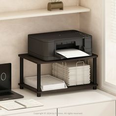 a laptop computer sitting on top of a desk next to a printer and printer tray