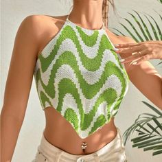 a woman wearing a green and white knitted crop top with an open neckline