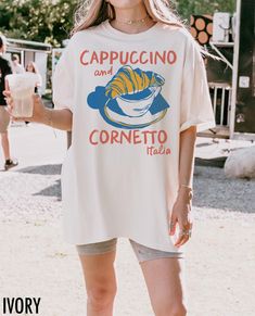 Savor the flavors of Italy with our Cappuccino and Cornetto graphic tee. This shirt brings the classic Italian breakfast to life, offering a stylish nod to la dolce vita with a charming retro vibe. We use professional quality DGT printing on all our apparel. Direct-to-garment, or DTG, is a high quality printing method that sprays ink directly onto the garment so there is no peeling or cracking. This fabulous graphic will be printed on a 100% cotton, Comfort Colors Unisex T-Shirt. Please refer to Food T-shirt, White Graphic Print T-shirt For Brunch, Short Sleeve Screen Print Tops For Brunch, Short Sleeve T-shirt With Screen Print For Brunch, Short Sleeve Screen Print T-shirt For Brunch, Cotton T-shirt With Letter Print For Brunch, White Short Sleeve T-shirt For Brunch, Funny Print Short Sleeve T-shirt For Brunch, White Crew Neck T-shirt For Brunch