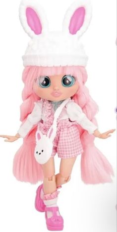 a doll with pink hair and bunny ears is standing in front of a white background