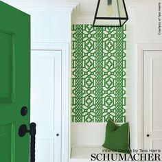 a green door is next to a white bench with a green wallpaper on it