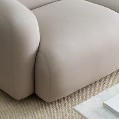 a close up of a couch on the floor with a marble table in the background