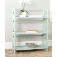 a blue shelf with some books and a bowl on it next to a flower pot