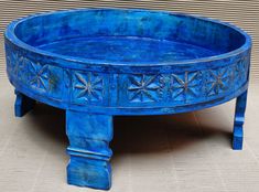 a blue painted wooden table with star designs on the top and bottom, sitting in front of a wall