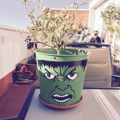 a potted plant with an angry face painted on it's side sitting on a table