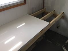 a white counter top sitting next to a window in a room that is being remodeled