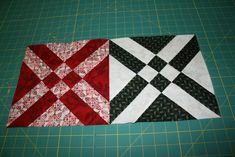 two quilted squares on a cutting board, one is red and the other is black