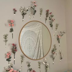 a mirror and some flowers on a wall