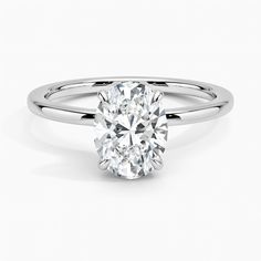 an oval cut diamond engagement ring on a white background, with the center stone visible