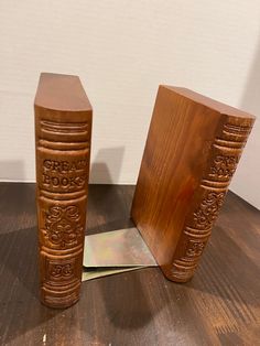 two wooden bookends sitting on top of a wooden floor next to each other