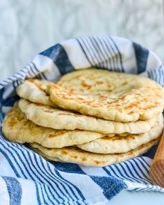 a stack of flat breads sitting on top of a blue and white towel