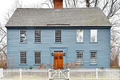 a blue house with a white picket fence