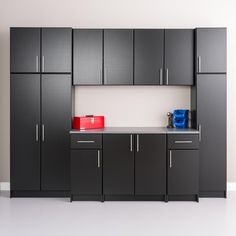 a room with cabinets, cupboards and a red bag on the counter top in front of it