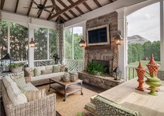 a covered porch with wicker furniture and a flat screen tv mounted on the wall