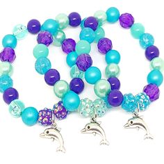 These adorable stretchy bracelets are the perfect favor for your little one's Under The Sea themed party! Each bracelet is made using an Tibetan silver charm, resin rhinestone beads and an assortment of 10mm acrylic beads in purple, blue and aqua strung with durable stretch floss cord. Each bracelet will arrive individually packaged in organza bags. Please message me if you have any questions, if you need a different amount of bracelets or if you would like your bracelets made in a different col Under The Sea Themed Party, Dolphin Bracelet, Under The Sea Birthday, Cardboard Jewelry Boxes, Sea Birthday, Small Jewelry Box, Stretchy Bracelets, Rhinestone Bead, Metal Charm