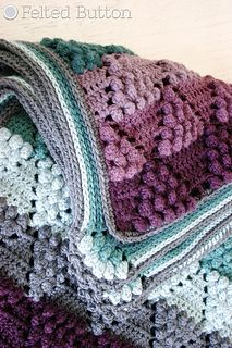 a crocheted blanket laying on top of a wooden floor