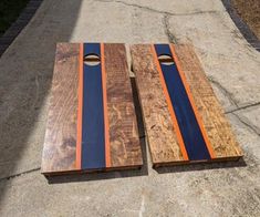 two wooden boards sitting on top of a cement ground next to each other with blue and orange stripes