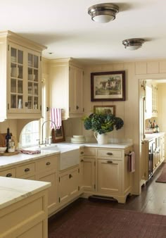 a kitchen filled with lots of counter top space and white cabinets next to a window