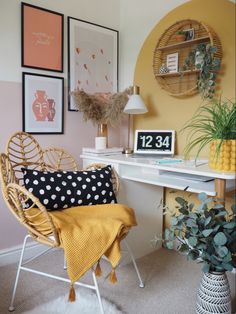 a desk with a chair, lamp and pictures on the wall in front of it