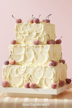 a three tiered cake sitting on top of a table next to a glass of wine