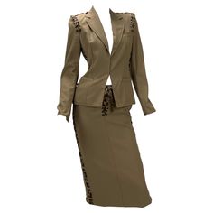 Tom Ford for Yves Saint Laurent Safari Skirt Suit S/S 2002 Runway Collection Fr. Size 36 - US 4 The tailored jacket is made of khaki cotton and features a sharp cut with sculpted, padded shoulders, front pockets, raw edges, a hook and eye closure at the front and two small vents at the back. It is constructed from several panels that are linked by intertwined bands of raw-edged leopard print silk running through gunmetal eyelets. 100% cotton, unlined. The skirt is made of khaki cotton as well, s Safari Skirt, Green Velvet Skirt, Vintage Skirt Suit, 90s Y2k Fashion, Tom Ford Clothing, Tom Ford Suit, Tailored Skirt, Black White Vintage, Blazer And Skirt