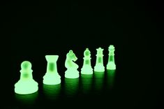 glowing chess pieces are shown in the dark