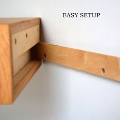 a close up of a wooden shelf on a white wall with holes in the wood