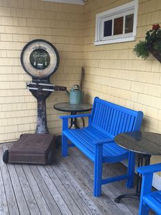 a blue bench sitting on top of a wooden floor next to a table and chairs