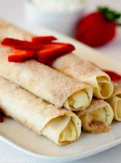 three crepes on a plate with strawberries