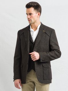 "O Ceallaigh Peat Colour Tweed Jacket With leather trims. This plain Donegal tweed patterned fabric has been designed to reignite your jacket collection. This tweed blazer has an earthy tonal composition making it perfect for both day and evening events. The traditional herringbone peat colored tweed contains flecks of green and brown, for an immediate feel of the Irish landscape. Cut with quirky design details, it has been designed with a nod to Irish historical events. This fabric champions ve Classic Brown Tweed Jacket With Patch Pockets, Brown Tweed Jacket With Patch Pockets For Fall, Brown Tweed Blazer With Pockets, Brown Wool Tweed Jacket With Patch Pockets, Classic Tweed Outerwear With Patch Pockets, Tweed Jacket With Pockets For Tailoring, Fall Tweed Jacket With Patch Pockets, Brown Single Breasted Tweed Sport Coat, Brown Tweed Single Breasted Sport Coat