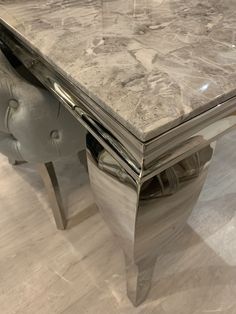 a marble top table with chrome legs in a room