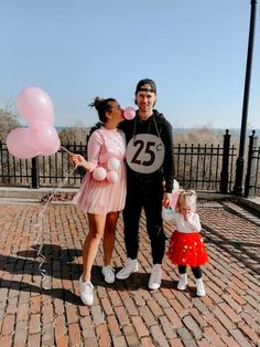 a man and woman standing next to each other holding balloons