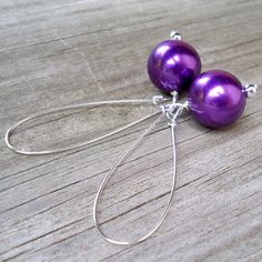 These handcrafted earrings are vibrant and beautiful! Silver plated kidney ear wires featuring a chunky 16mm round metallic royal purple faux pearl and measuring almost 3 inches in length. A bright POP of royal color! Item is carefully packaged and shipped via USPS in a sturdy protective mailer. Check out more fabulous jewelry and enter my shop here: https://www.etsy.com/shop/jewelbytessyla View the positive feedback I've received from customers and check out some beautiful art prints for nurser Handmade Purple Drop Clip-on Earrings, Nickel-free Round Purple Earrings, Nickel-free Purple Beaded Earrings, Nickel-free Purple Teardrop Earrings, Nickel-free Purple Sterling Silver Beaded Earrings, Bright Pop, Black Earrings Dangle, Royal Colors, Faux Pearl Earrings