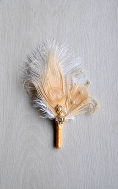 a feathered boutonniere on a white surface