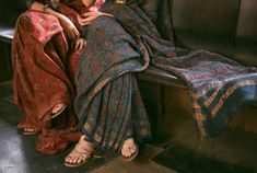 two women sitting next to each other on a bench