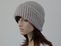 a mannequin head wearing a gray crochet hat