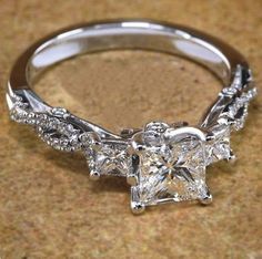 an engagement ring with three princess cut diamonds