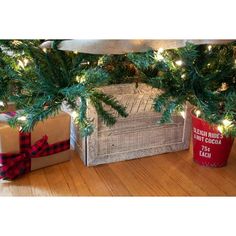 a christmas tree with presents under it on the floor