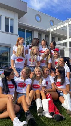 a group of young women sitting next to each other in front of a white building