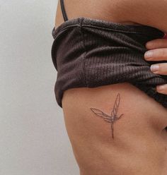 a woman's stomach with a small flower tattoo on it