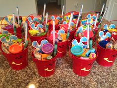 red buckets filled with toys sitting on top of a counter