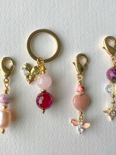 four different types of keychains with charms attached to them on a white surface